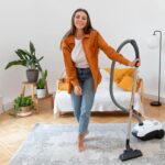 Full-shot-woman-holding-vacuum-cleaner
